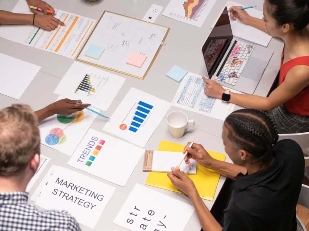 Team members reviewing marketing strategy charts, trend graphs, and data during a business planning meeting